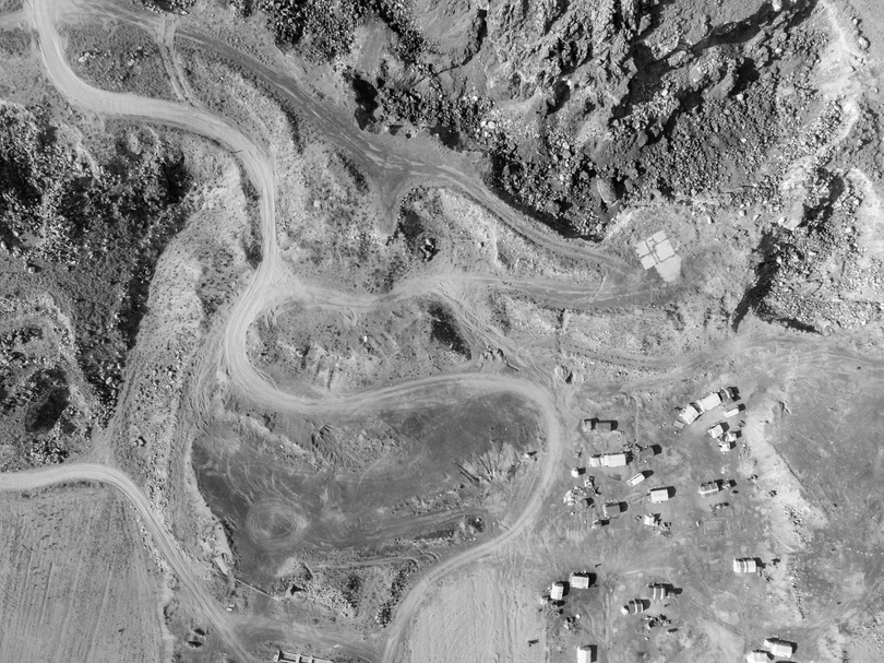 a black and white image of a road in the mountains